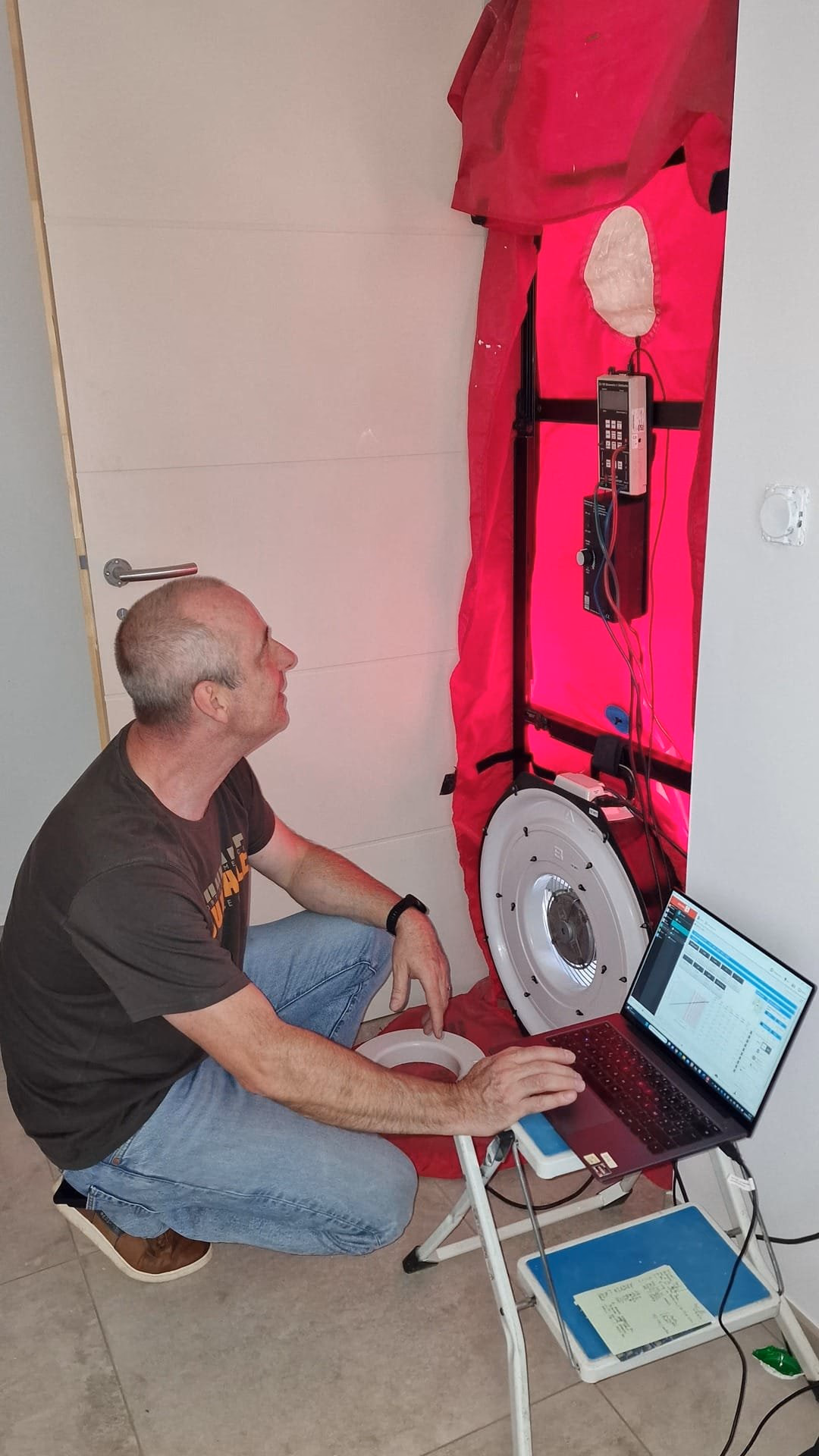 Test de perméabilité à l’air en cours – porte soufflante Technicien réalisant un test d’infiltrométrie avec une porte soufflante dans une maison neuve