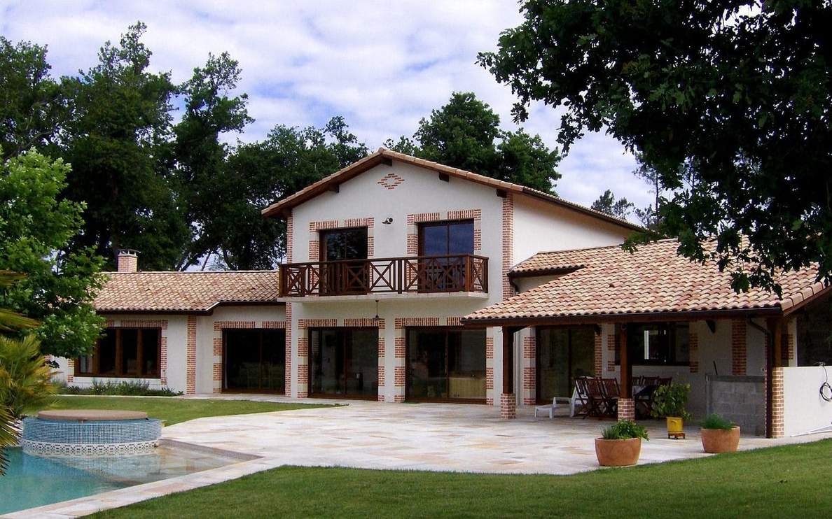 Maison R+1 de 187 m² à Lesperon avec charpente traditionnelle, menuiseries K-Line RAL 8007, tuiles Terreal vieilli Castel et enduit blanc cassé