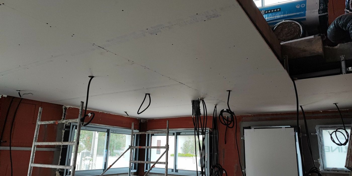 Pose de faux plafond en plaques de plâtre et passage des gaines électriques sur un chantier de rénovation à Capbreton par Landes Habitat