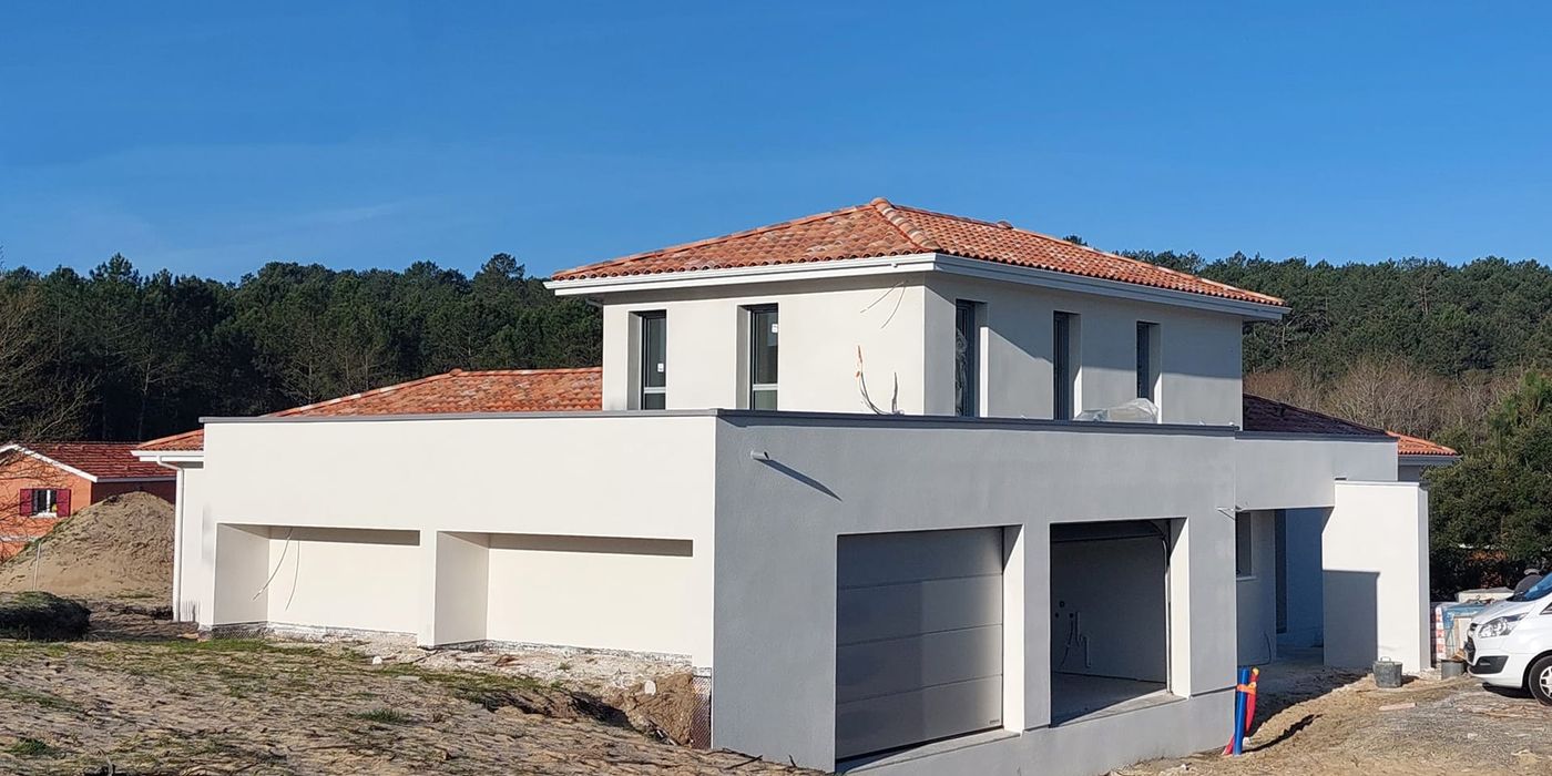 Vue d'une maison en construction Lit-et-Mixe avec enduit blanc et toiture mixte