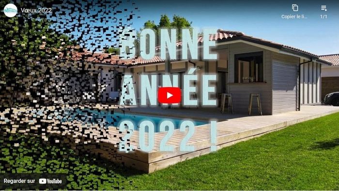 Une maison moderne avec bardage gris, terrasse en bois et piscine rectangulaire dans un jardin.
