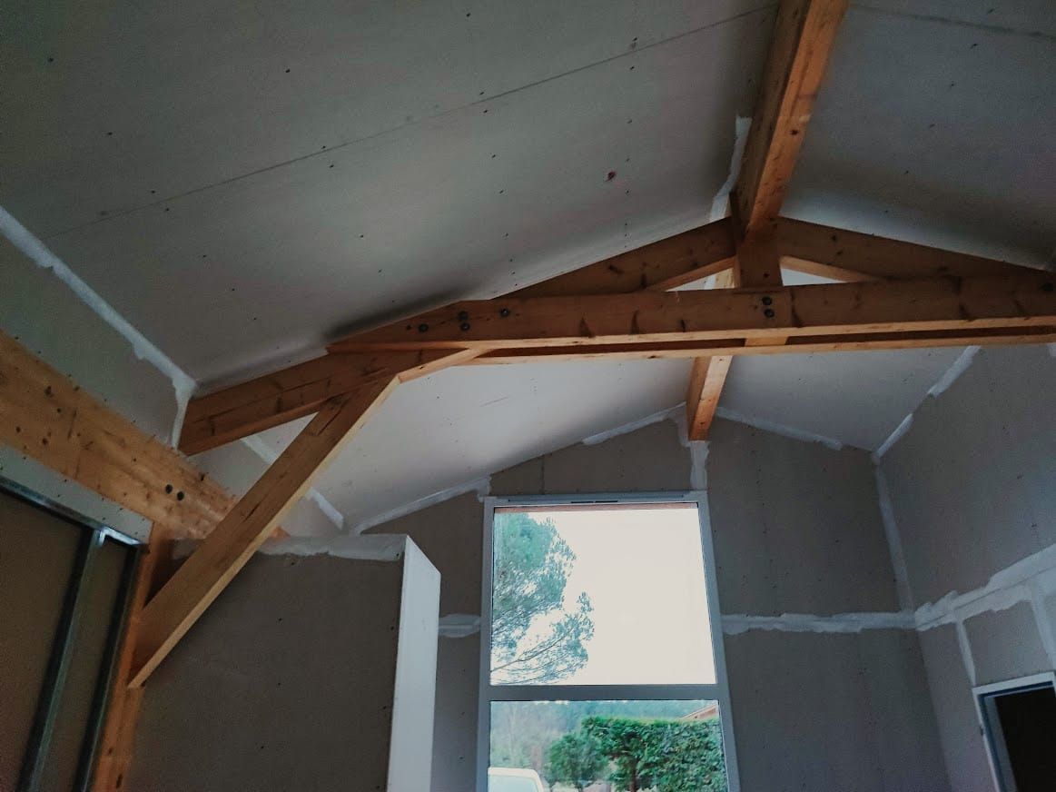 Intérieur de maison à Vielle-Saint-Girons avec plâtrerie terminée et charpente apparente