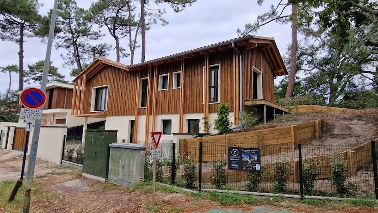 Vue de la façade avant d'une maison individuelle contemporaine avec bardage bois vertical, construite par Landes Habitat.